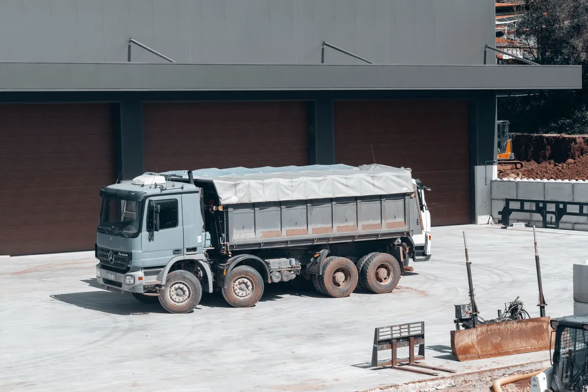 Tipper truck at a GCC construction site, red-earth embankment behind it