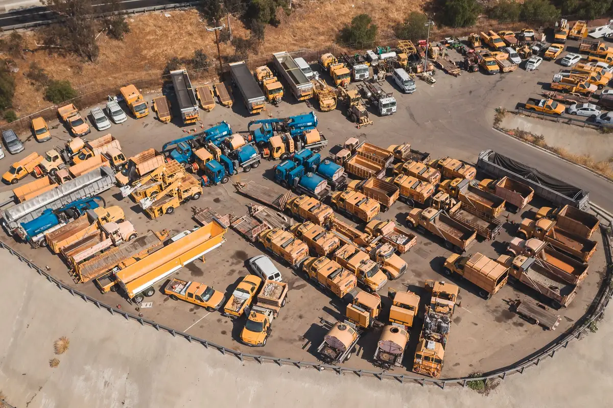 Aerial view of a mixed commercial fleet yard: tippers, water tankers and service vehicles